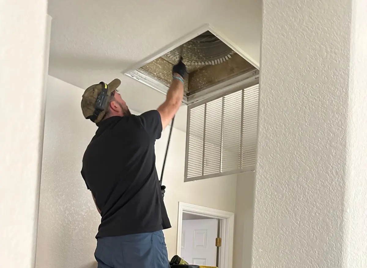 Certified technician performing professional air duct cleaning in a Roseville home